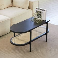 a coffee table with a magazine rack on it in front of a couch and sofa