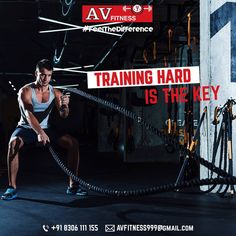 a man holding a rope while standing in front of a wall with an ad on it