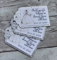 three tags with wedding pictures on them sitting on top of a wooden table next to each other