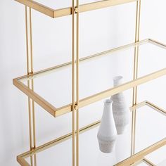 two white vases sitting on top of a glass shelf