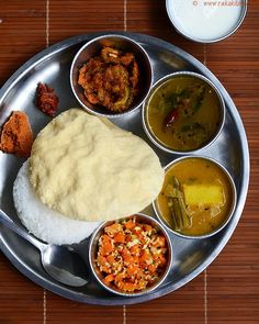 a silver plate topped with different types of food next to two cups of milk and sauces