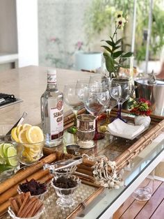 a table with wine glasses, lemons and other food items on top of it