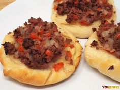 three pieces of bread with meat and vegetables on it sitting on a plate next to another piece of bread