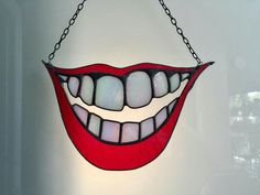 a stained glass mouth hanging from a chain