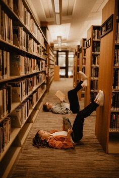 two people laying on the floor in a library