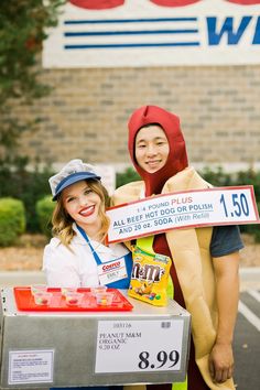 two women in costumes standing next to each other holding a sign that says walmart