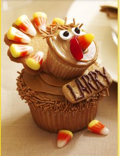 a cupcake decorated like a turkey sitting on top of a table