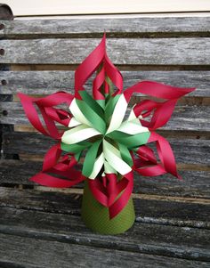 a red and white pinwheel sitting on top of a wooden bench