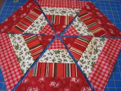 a red and white patchwork quilt on a cutting board