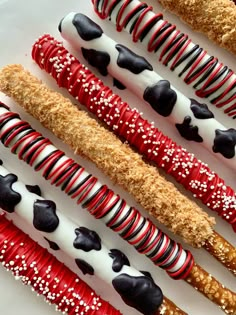 there are many different types of candy canes on the white plate with red and black stripes