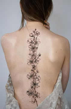 the back of a woman's neck with flowers on it