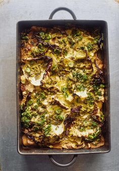 a square casserole dish with broccoli and cheese in it on a metal surface