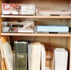 the shelves are filled with files, folders and other office supplies in clear plastic containers