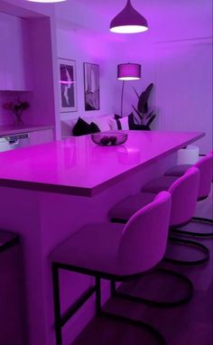 a kitchen with purple lighting and bar stools