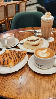 a table topped with coffee and pastries on top of white plates next to each other