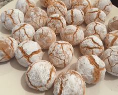 powdered sugar covered donuts are on a white plate and ready to be eaten