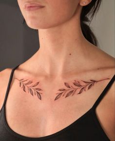 a woman's chest with leaves tattoo on her left shoulder and right breast area