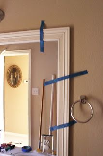 a mirror with blue tape taped around it and some tools on the table in front of it