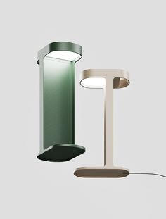 two lamps are next to each other on a gray background, one is green and the other is white