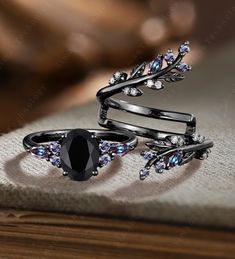 three black rings with crystal stones and leaves