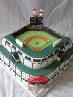 a cake shaped like a baseball stadium with green and white tiles on the top tier