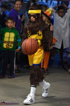 a man dressed as a monkey with a basketball in his hand while people watch from the sidelines