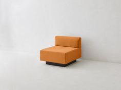 an orange chair sitting on top of a white floor in front of a white wall