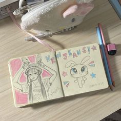 an open notebook sitting on top of a desk next to a stuffed animal and pencil