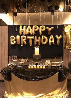 a birthday party with gold balloons and cake