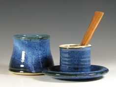 two blue cups and saucers with wooden spoons