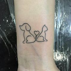 a small dog and cat tattoo on the left inner wrist, with a heart in the middle