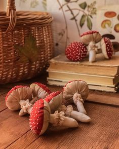 three little mushrooms sitting on top of a wooden floor next to a basket and books