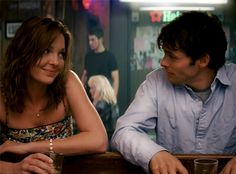 a man sitting next to a woman at a bar