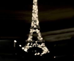 the eiffel tower lit up at night in black and white with lights on it