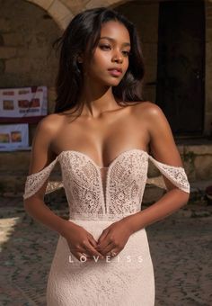 a woman in a wedding dress posing for the camera with her hands on her hips