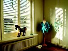 a dog figurine sitting on top of a window sill next to a radiator