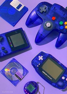 an assortment of video game controllers and accessories on a purple surface with a keychain