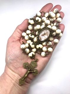 LARGE 5 Decade Catholic Rosary: 10mm Creamy White Riverstone Beads (53 Beads) 14mm Creamy White Rondelle Beads as Pater Beads 2 Inch Bronze Pardon Indulgence Crucifix Handcrafted (myself) Bronze Image of Mary, Jesus & The Lamb Center 130 Bronze Bead Caps Antique Bronze Wire RIVERSTONE - believed to energize your whole being and helps you make the changes that lead to deeper spiritual experiences which makes it a great stone for rosaries! BRONZE: A metal highly prized for its strength and dur Images Of Mary, Religious Crafts, Decade Rosary, Celtic Heart, Holy Rosary, Catholic Jewelry, Team Board, The Lamb, Rosary Catholic