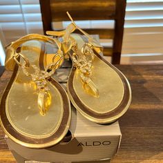 Aldo Women’s Sandal. Style Coquitlam-82. Brand New In Original Box. Gold Closed Toe Synthetic Sandals, Gold Cushioned Flip Flops For Vacation, Elegant Synthetic T-strap Sandals For Beach, Casual Gold Flip Flops For Parties, Elegant Gold T-strap Sandals For Beach, Gold Elegant Flip Flops, Gold Flat Sandals With Cushioned Footbed, Casual Gold T-strap Toe Post Sandals, Adjustable Cushioned Sandals For Party