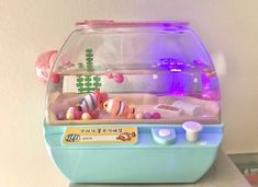 a fish tank filled with lots of toys on top of a white counter next to a wall