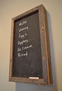 a chalkboard with writing on it hanging from the wall next to a sign that reads milk, honey, apples, ice cream and bread