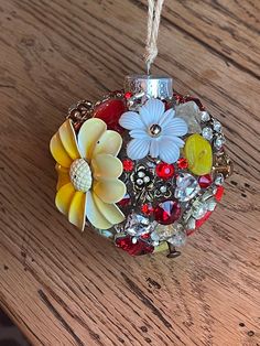 a glass ornament with flowers on it sitting on top of a wooden table