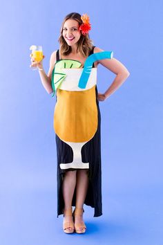 a woman in a costume holding a glass of orange juice while standing on a blue background