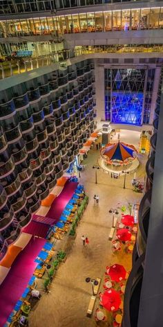 an aerial view of the inside of a large building with many tables and umbrellas