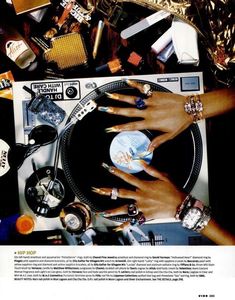 a woman's hands on top of a record player surrounded by jewelry and other items