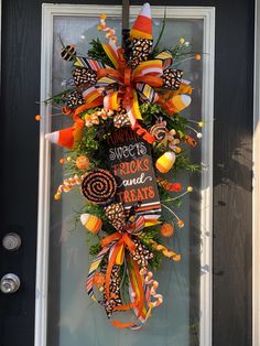 a halloween wreath with candy and treats hanging on the front door