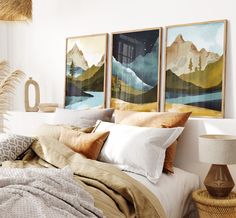 a bedroom with three paintings on the wall