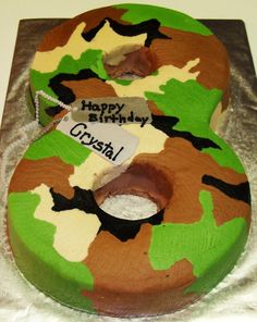 a camouflage birthday cake with the number 3 on it's side and a tag that says happy birthday crystal