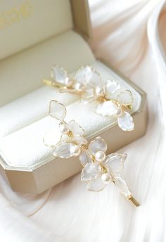 The Lyra bridal hair slides are the perfect accessory to complete your wedding day look. With their simple yet sophisticated design, these slides will seamlessly blend into your hairstyle, allowing your natural beauty to shine.  DETAILS ❁Set of 2 hair sildes. ❁Handcrafted dip resin flowers with shinny and translucent finish. ❁Minimalist design with simple outline with delicate crystal pearl details. ❁Designed and handmade in Canada. Worldwide shipping. ❁Beautifully gift wrapped in our signature Dip Resin, Pearl Bridal Hair, Unique Wedding Jewelry, Hair Slides, Petite Earrings, Pearl Details, Pearl Bridal, Wedding Hair Pins, Hair Slide