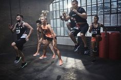 a group of men and women running in a gym